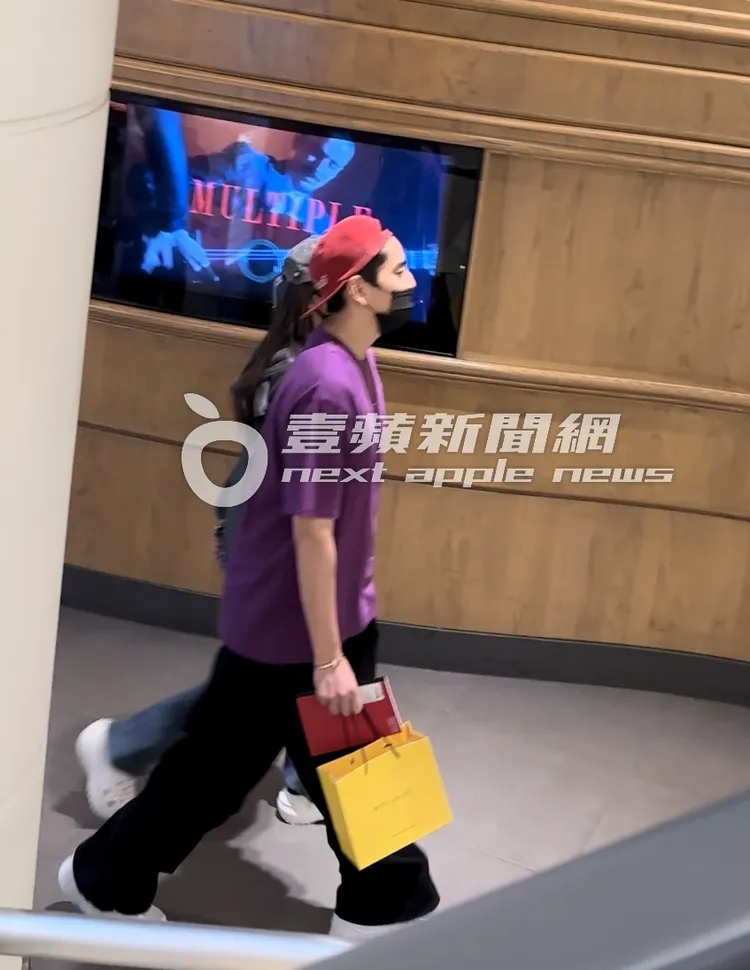 王大陸提著「PETIT SAM LIU」可麗露紙袋及一本目錄。特勤中心攝