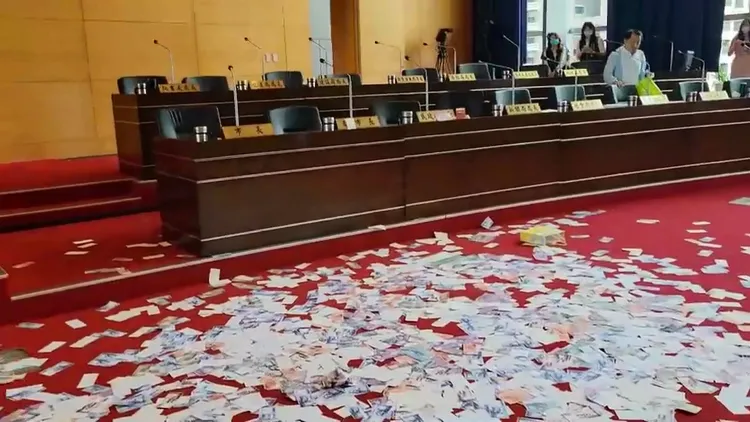 中午議程結束，官員及市議員都離開，留下滿地的假鈔。江和樹提供