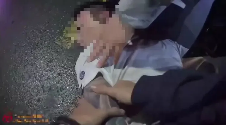 警方將吳男壓制在地。三重警分局提供