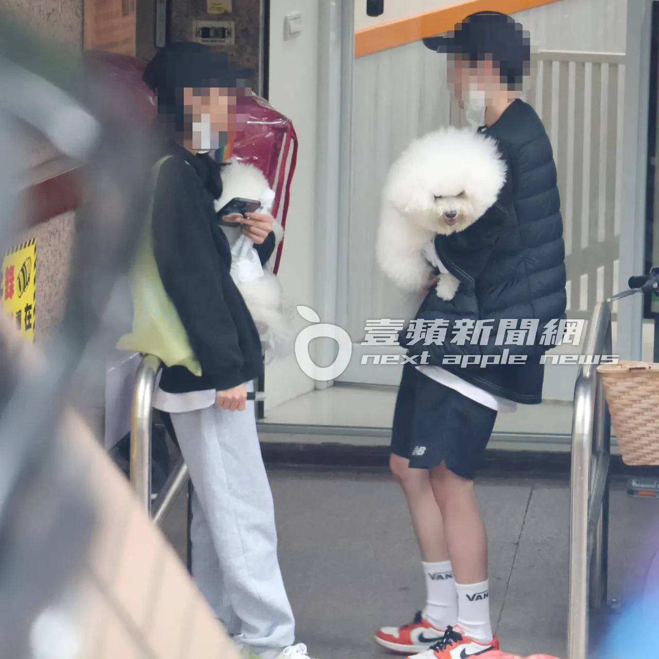 女孩们在骑楼下，抱著Jolin爱犬屋虎（右）跟社长，抽同一支烟笑开怀。特勤中心摄