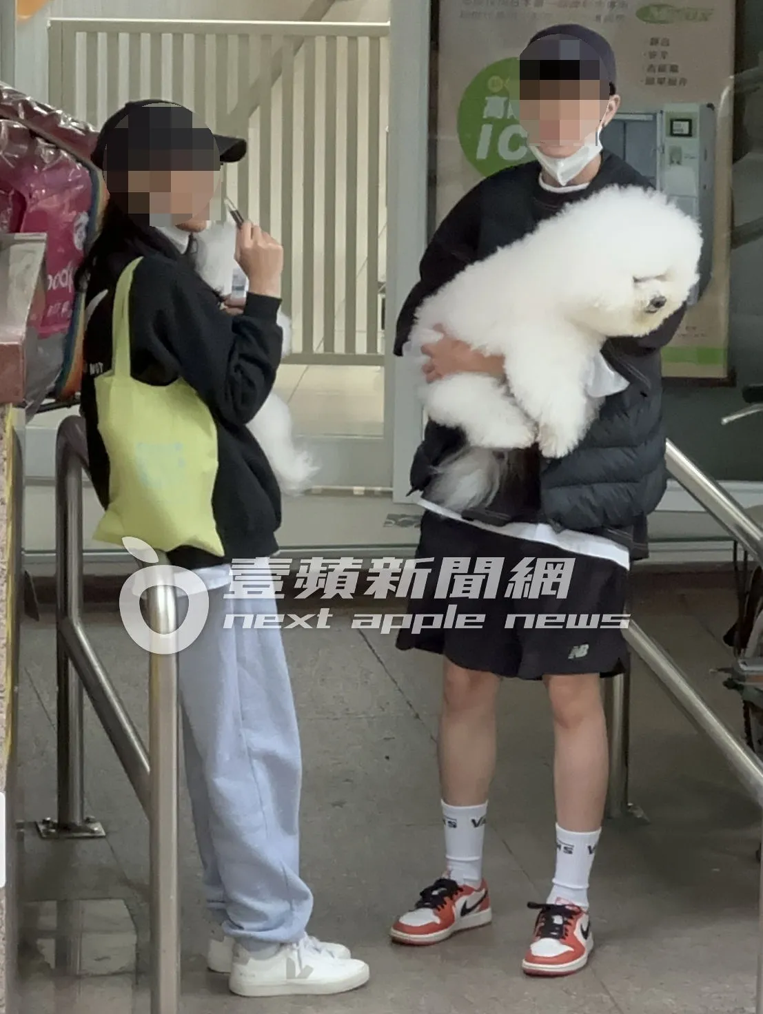 女子（右）抱著蔡依林16岁爱犬屋虎在动物医院门口，换另名女孩在旁抽电子烟。特勤中心摄