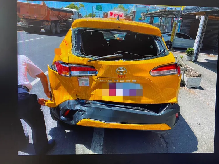 黃豪平昨在屏東搭計程車，遭後方砂石車撞上，計程車後窗破裂、車尾凹陷。讀者提供