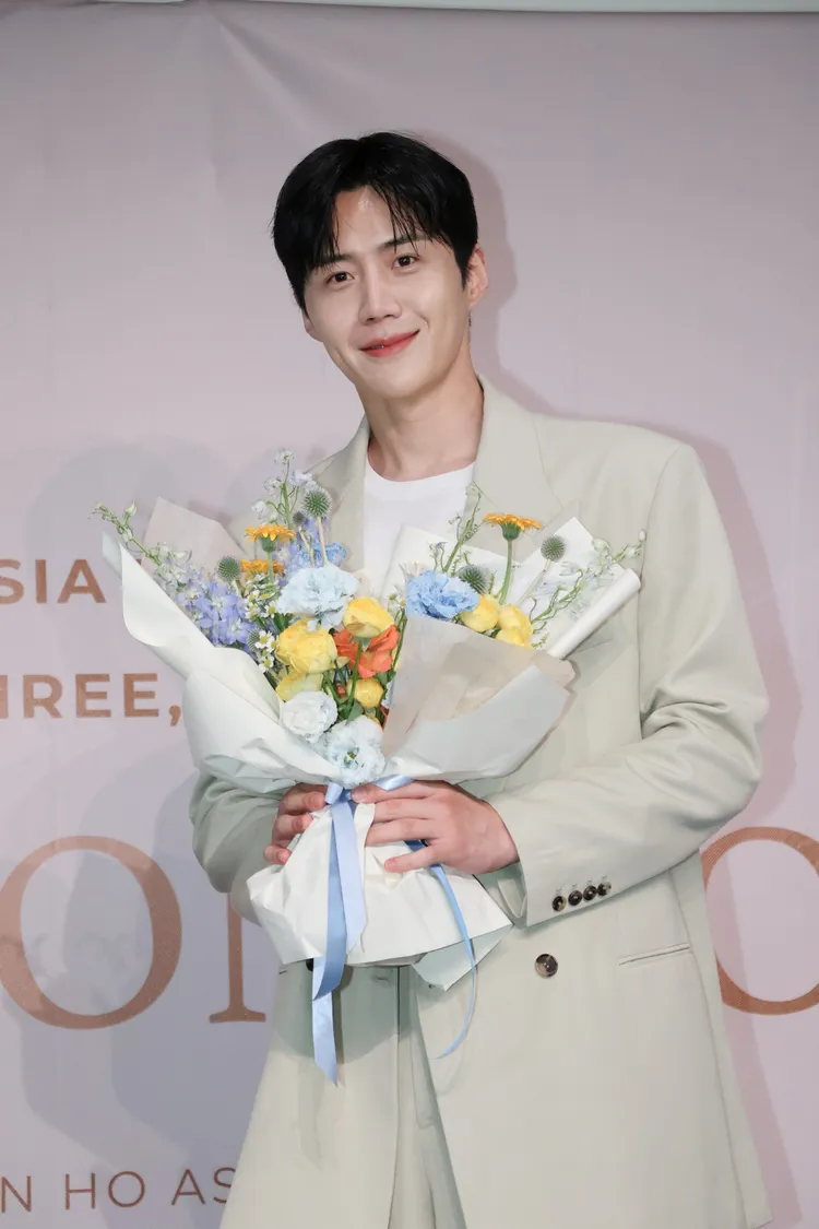 金宣虎拿著主辦單位送的花束，自嘲不太會擺姿勢。鄭孟晃攝