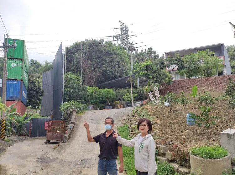 當地居民李清貴（左）說，這座以貨櫃疊成的「樂高隔音牆」，離他家只有30公尺。張芬郁辦公室提供