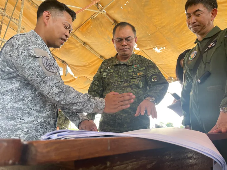 菲律賓空軍人員17日與森蒂諾（中）簡報跑道興建進度。路透社