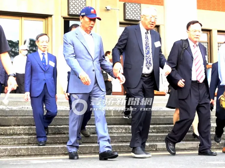 郭台強（右二）牽起哥哥郭台銘的手走下階梯。特勤中心攝