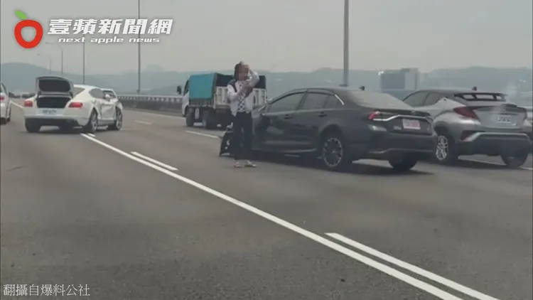 兩車都損毀橫停在高速公路上，疑似黑色Altis車主焦急地撥打電話求救。翻攝自臉書「爆料公社」