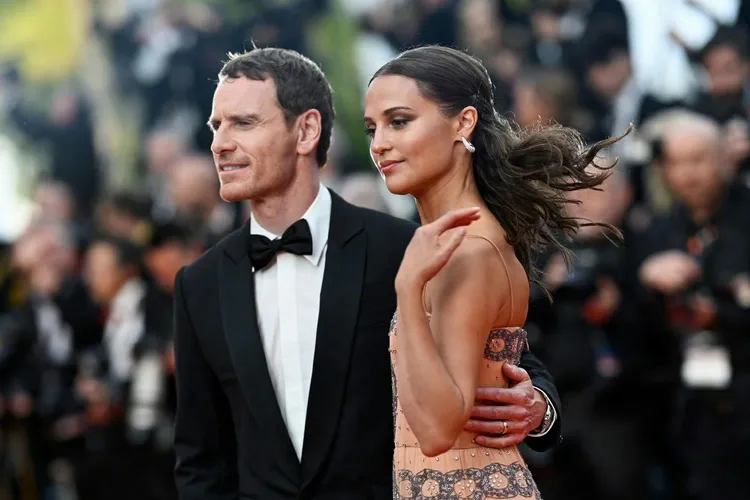 「萬磁王」麥可法斯賓達（左）帶著愛妻「丹麥女孩」艾莉西亞薇坎德手牽手出場。美聯社