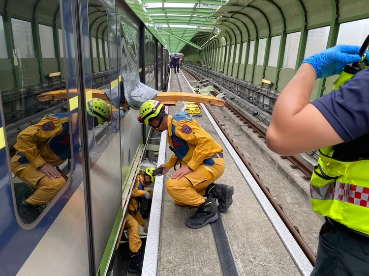 消防人員搶救受困在車廂底部的林姓女乘客。民眾提供