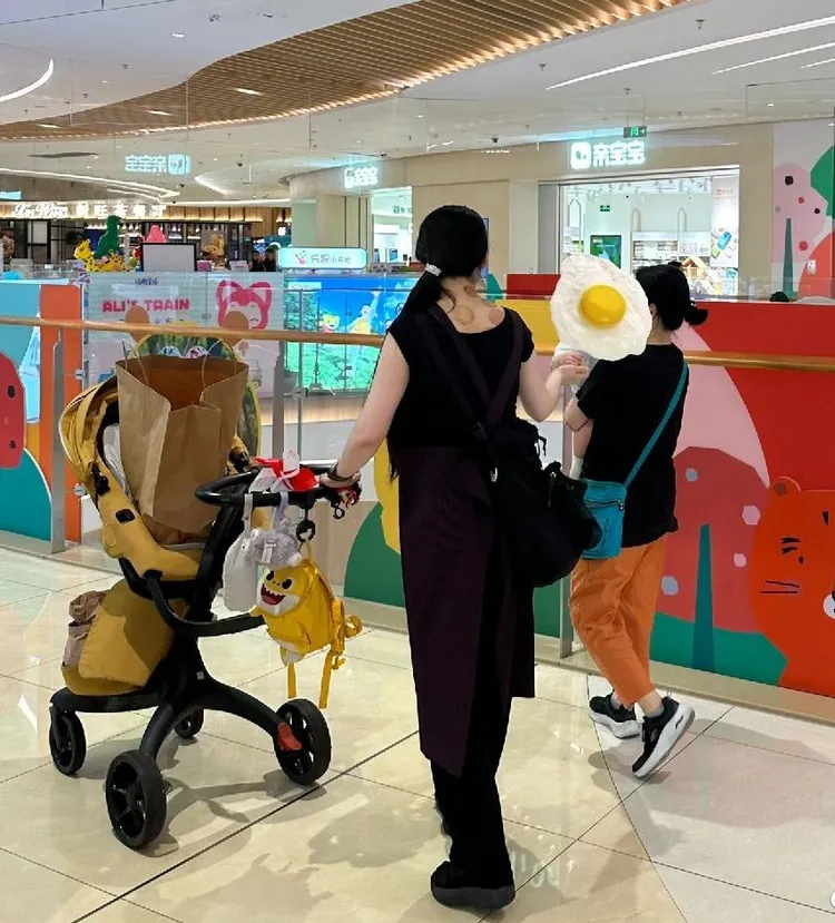 一身黑的郭碧婷推著嬰兒車，保母幫忙抱小孩。翻攝芒果撈小萌主微博