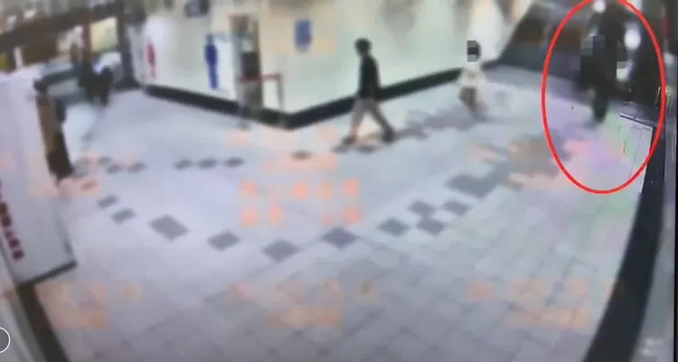 被害妙齡女(中間白衣者)嚇得趕緊跑開，向捷運服務櫃台求助。翻攝畫面