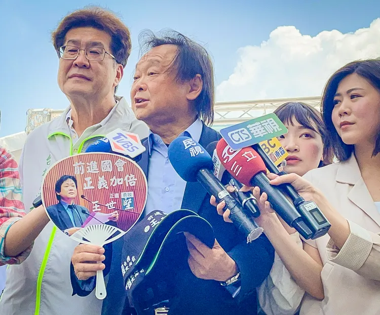 王世堅在鏡頭前展示競選小物。賴昀岫攝