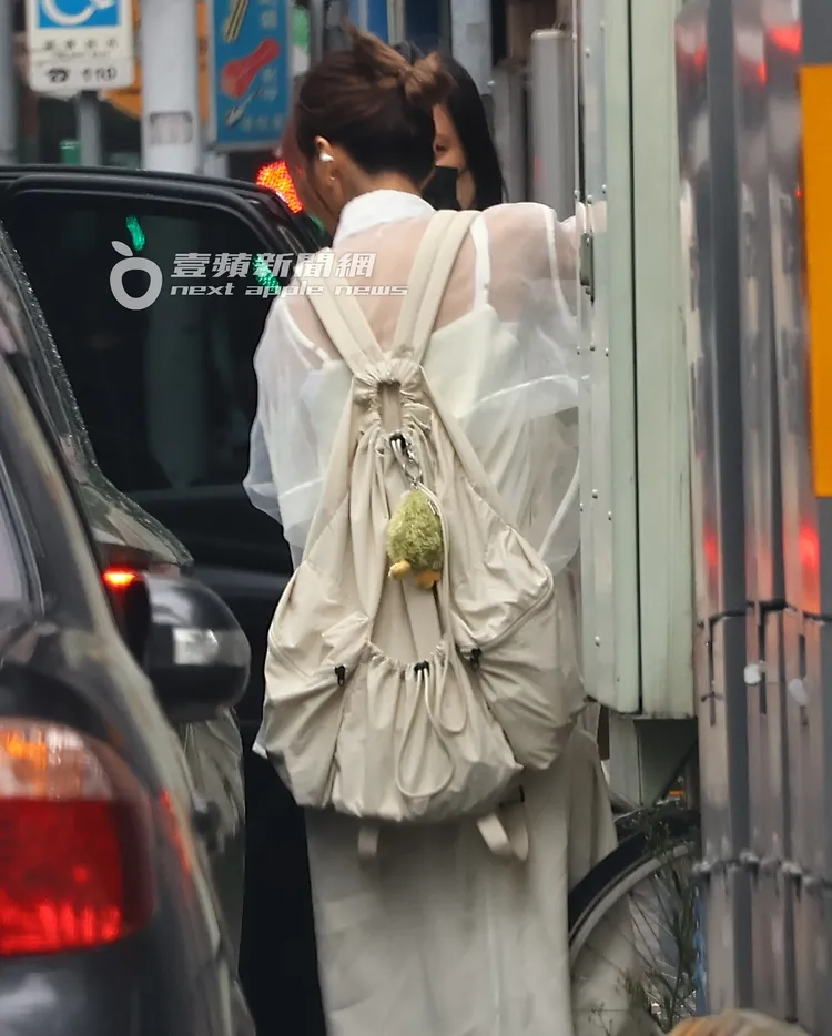 豆花妹背著米白色束口包下車。特勤中心攝