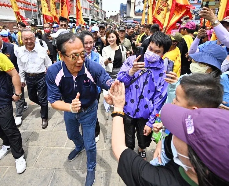 郭台銘今天出席百年洗港祭江開幕式媽祖遶境起駕，民眾與他擊掌。郭辦提供