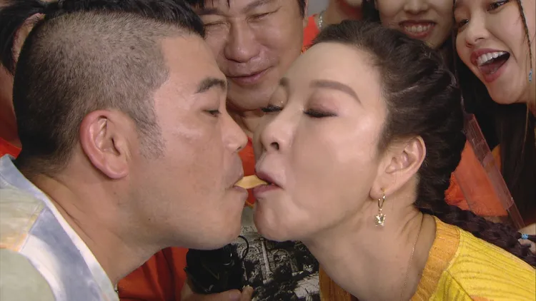 楊繡惠（右）嘴巴說不要，但仍硬著頭皮與馬國畢互吃餅乾。民視提供