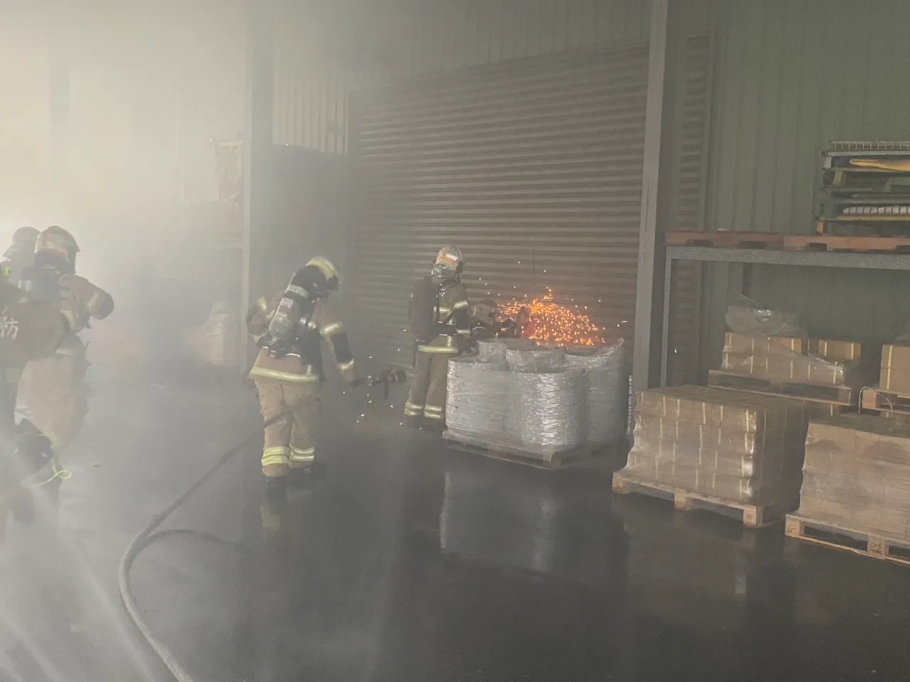 警消持電鋸破門救火。讀者提供