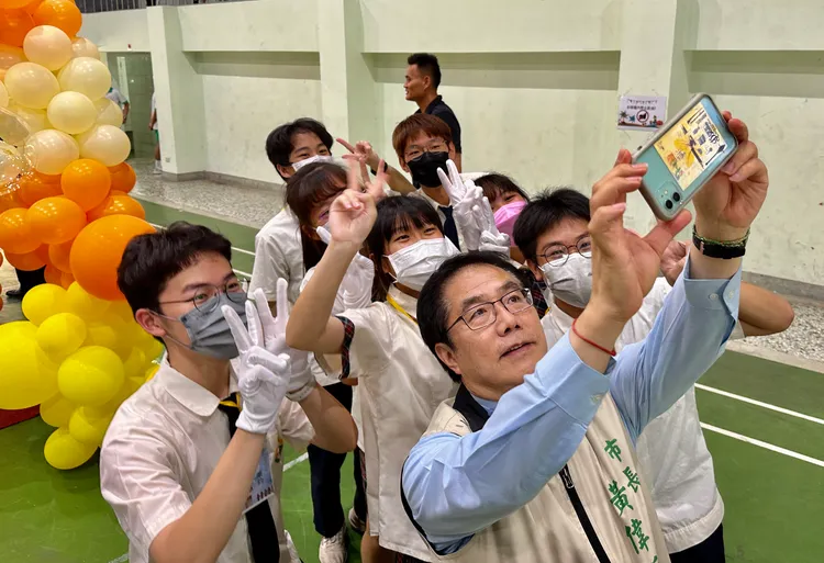 畢業生搶著合影，黃偉哲來者不拒。市府提供