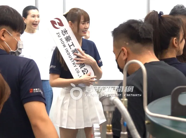 中信兄弟啦啦隊女神短今（中），拿著廠商的廣告牌，等待幸運粉絲排隊合照。特勤中心攝