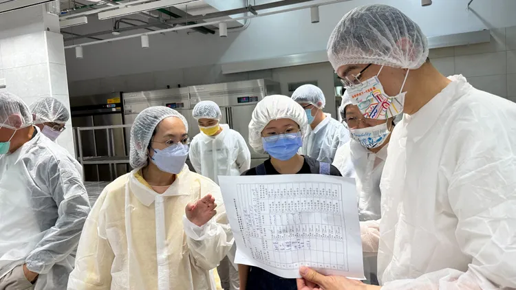 謝國樑查看學校廚房作業流程。翻攝照片