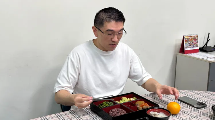 謝國樑親自試吃營養午餐。翻攝照片