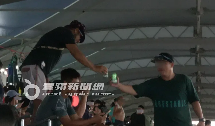 張震嶽（左）大方地與協會主持人拿起啤酒罐敲杯，乾一口解渴。特勤中心攝