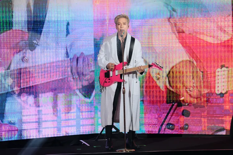 鄭容和穿著白色長大衣，背電吉他登場。彭欣偉攝