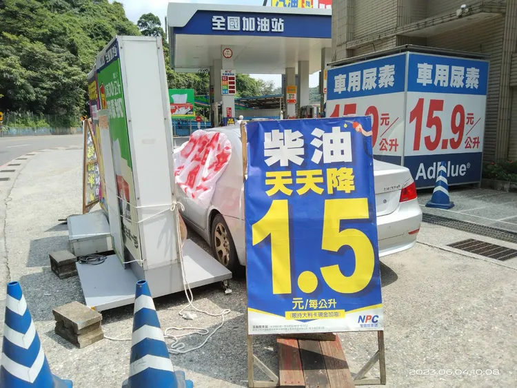 車主表示，加油站為了遮擋布條，用各種廣告看板把自己的車圍住。翻攝照片