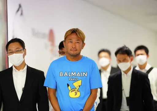 前網紅議員淪國際通緝犯!穿名牌T返日 機場遭上銬逮捕露詭異微笑