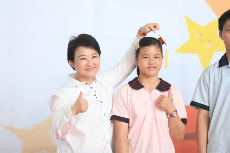 盧秀燕特別用手指著四方帽與學生合照。市府提供