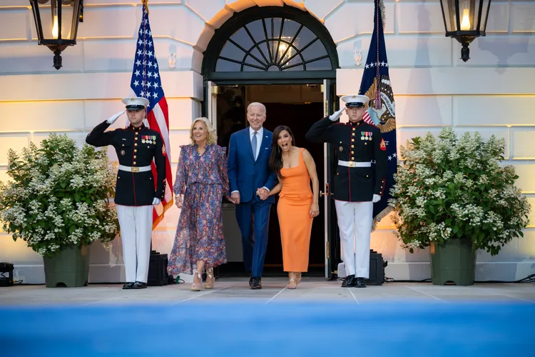 拜登親暱地拉著女星伊娃隆格莉亞(橘色洋裝)的手出席電影首映會。翻攝自推特