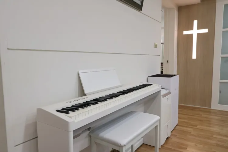 林媽媽是鋼琴老師，一旁有訂製代表信仰的十字架木工裝潢。鄭孟晃攝