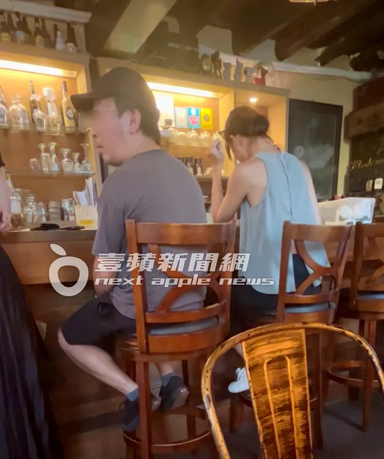 「憨厚男」和員工聊天，鍾瑶（右）則在旁看手機訊息。特勤中心攝