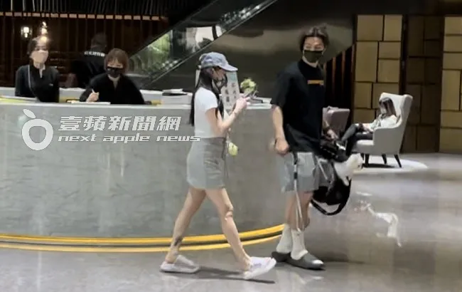 熊熊（左）與新歡「博美男」拿著愛犬，走進台北時代大樓服務台換證。特勤中心攝