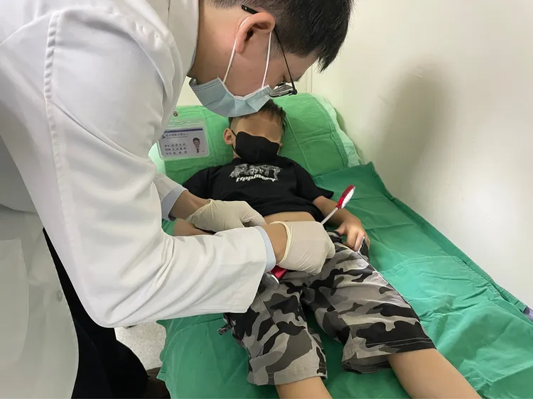 張朋暉醫師為男童進行檢查。院方提供