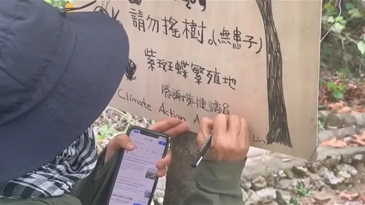 行動藝術家林俐貞製作告示牌，請民眾不要搖晃樹木。詹家龍導演提供