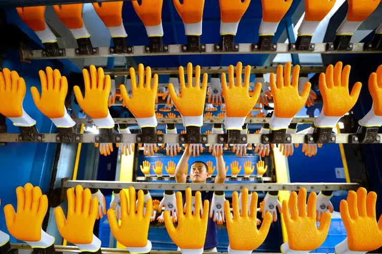 中國央行指目前人民幣的貶值，高度可控；圖為山東高密市一間手套工廠的員工。美聯社