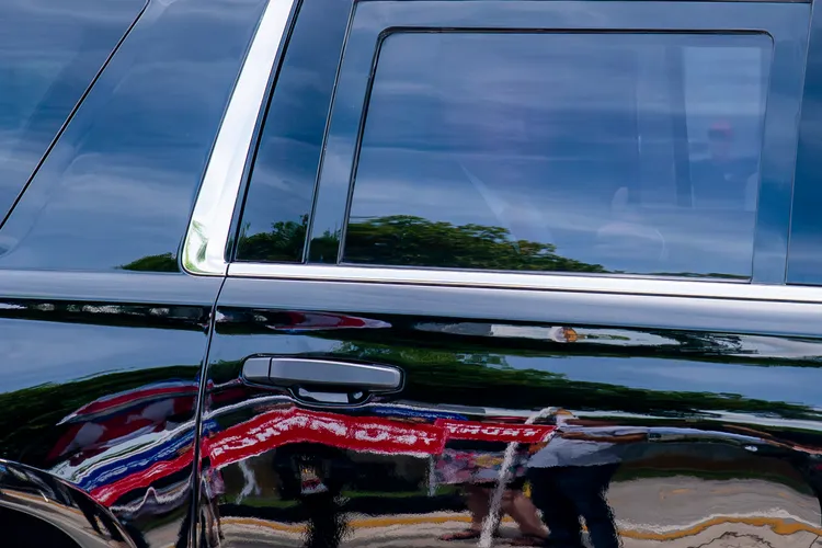 川普在車內向支持者比起大拇指。美聯社