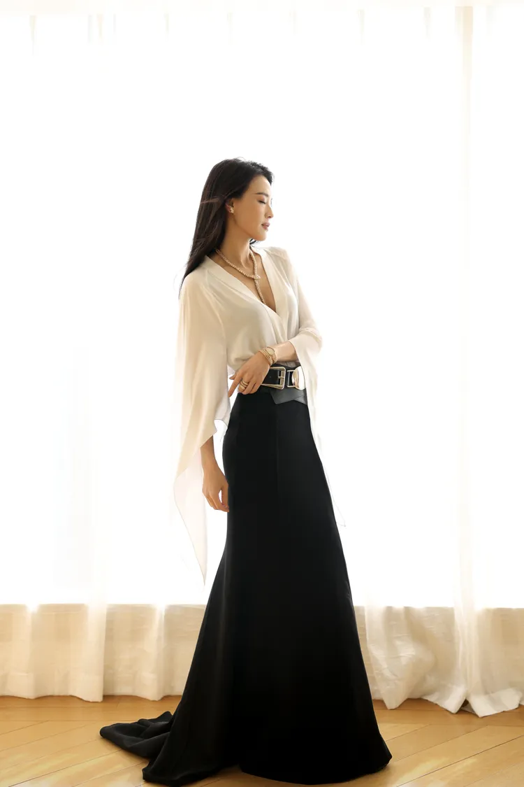 她在微博電影之夜活動上，演繹了所代言的MK 2023秋冬系列白色真絲上衣，搭配黑色羊毛魚尾裙以及Gloria黑色小牛皮腰帶。翻攝sqwhat IG
