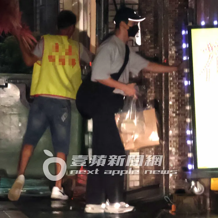 朋友把大門打開，許光漢提著食物和伴手禮進門上樓。特勤中心攝