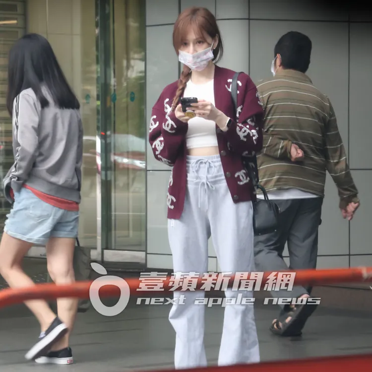 王心凌露雪乳蠻腰邊滑手機，不忘抬頭看計程車來了沒。特勤中心攝