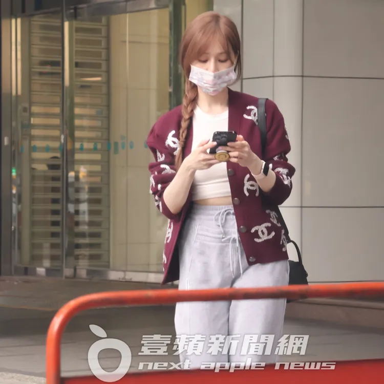 王心凌穿香奈兒外套，邊滑手機邊等計程車來。特勤中心攝