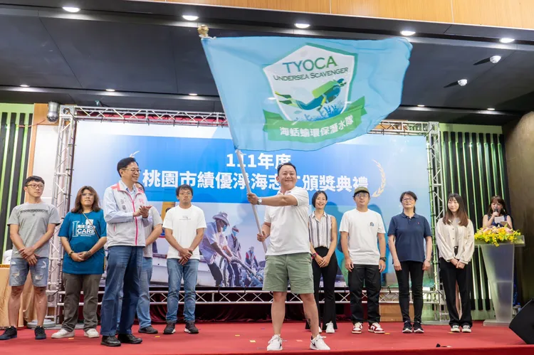 張善政為新加入的志工隊授旗。桃園市府提供