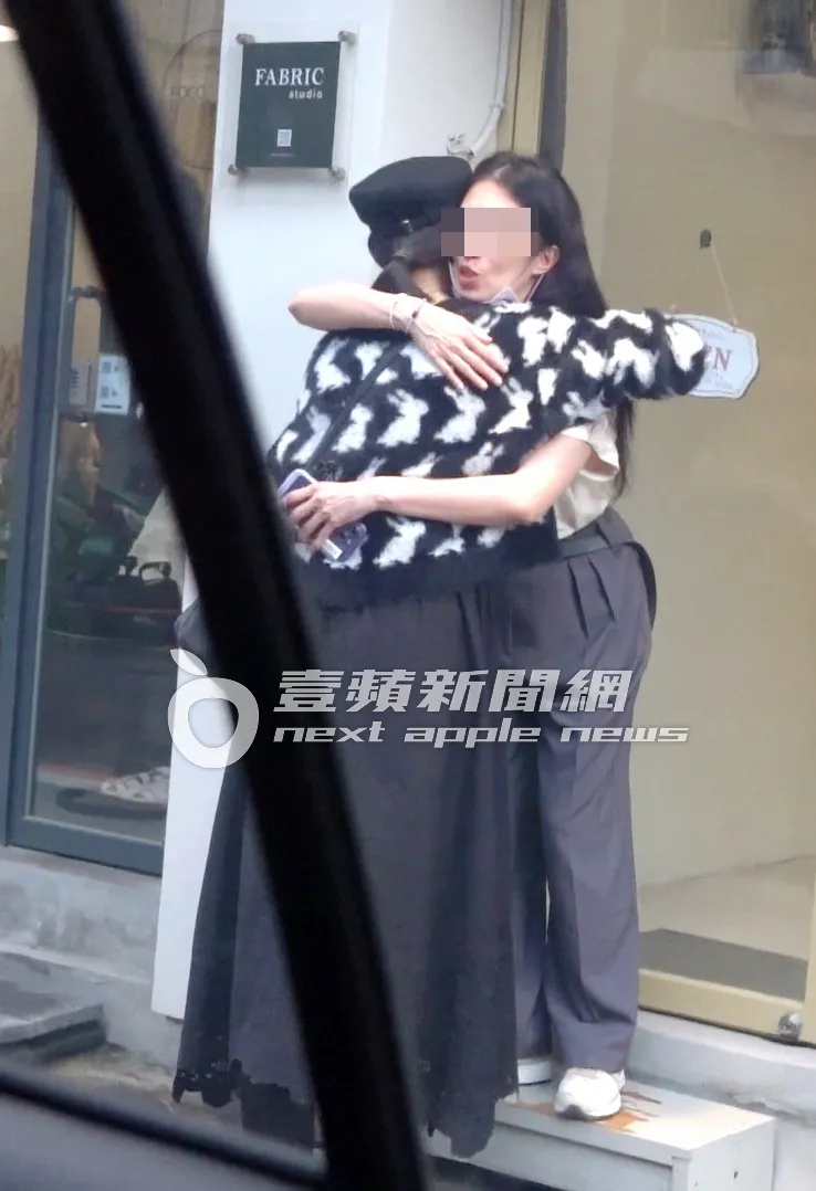 在服飾店外，陸明君（左）與友人互相擁抱道別，畫面溫馨。特勤中心攝
