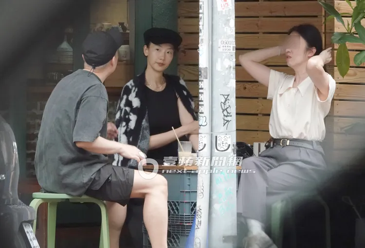 陸明君（中）披上乳牛外套與友人們聊天。特勤中心攝