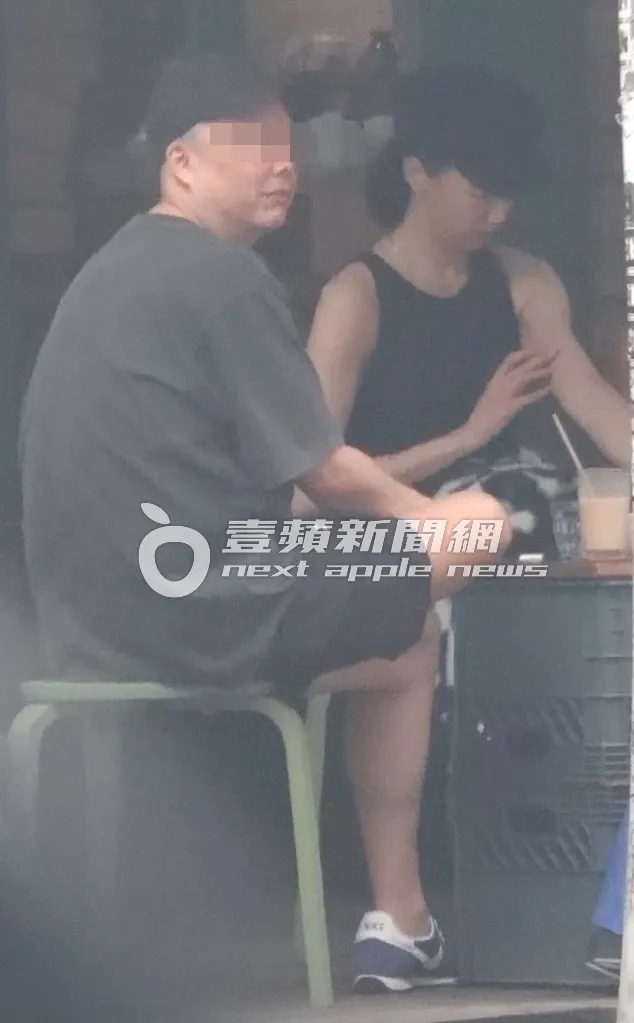 穿著無袖的陸明君（右）坐在戶外，被蚊蟲叮咬，隨後拿起包包內的藥來塗抹傷口。特勤中心攝