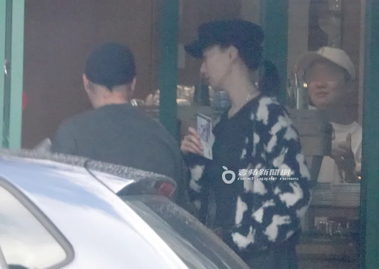 陸明君（右）拿著藍色千元大鈔準備結帳，卻被友人請客搶先結帳。特勤中心攝