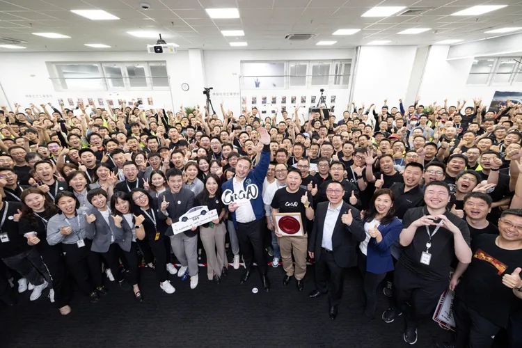 特斯拉創辦人馬斯克（中、舉手者）與特斯拉上海廠員工合照。路透社