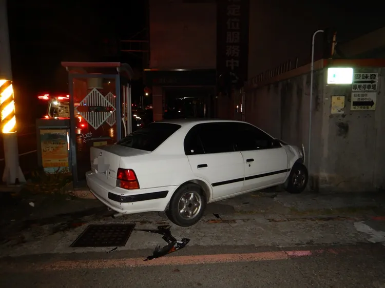白車轉彎與直行機車發生車禍後失控撞牆。讀者提供