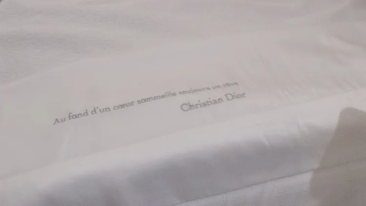 床單上繡有Dior先生的名言「Au fond de chaque coeur sommeille un reve」，意指「每個都有沉睡在心底的夢想」。張家玲攝