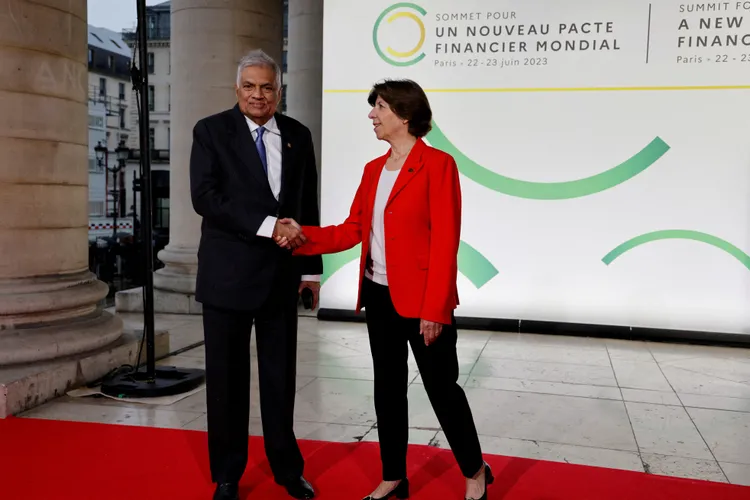 威克瑞米辛赫（左）上月赴巴黎參加全球氣候金融峰會，右為法國外交部長柯隆納。路透社